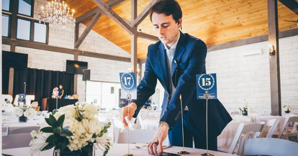 An ETSU student setting up for an event by placing numbered cards on a table.