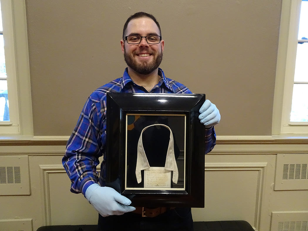 Corbin holding the shadowbox that contains Uncle Dace Macon's collar.