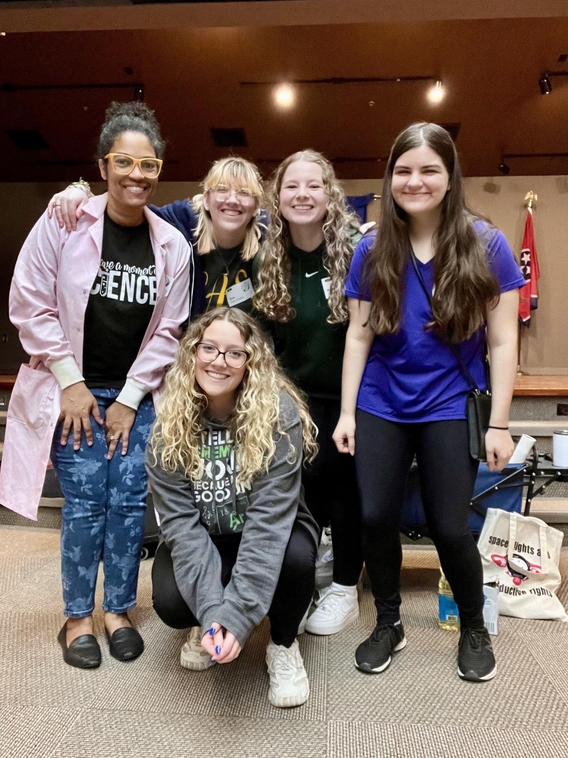 Four students posing for a picture with Professor Butler at the Chemistry Club Physics Camp. 