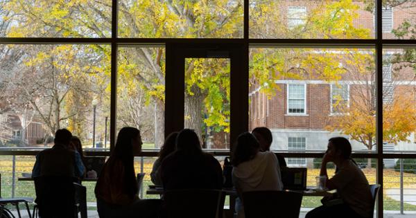 Students sitting around a table with the outdoors visible through the window