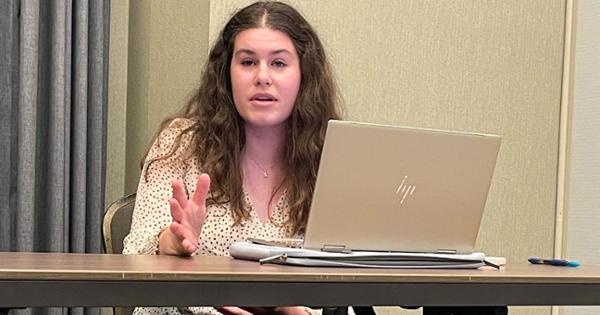 Student sits behind laptop talking