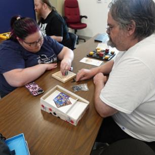 Dr. Beeler and a student playing a board game.