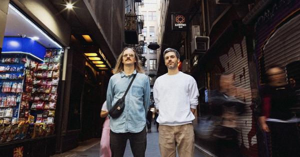 Photo of artists Justin STanton and Chris Bullock on a blurred and busy street. 