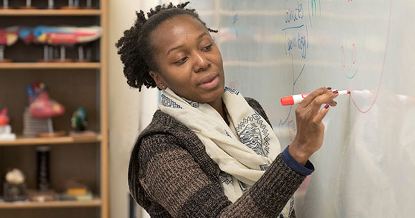 A person writing on a whiteboard.