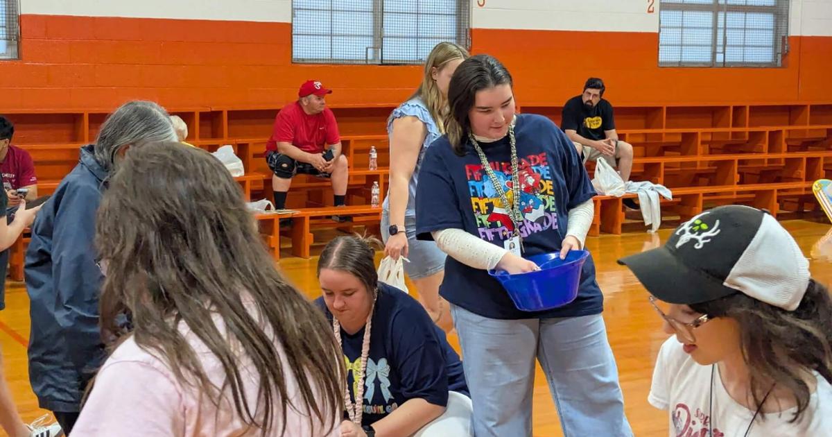 Teachers handing things out as students walk by