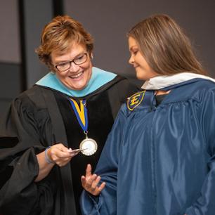 Photograph of faculty and student during graduation