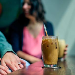 A picture of coffee with individuals in the background.