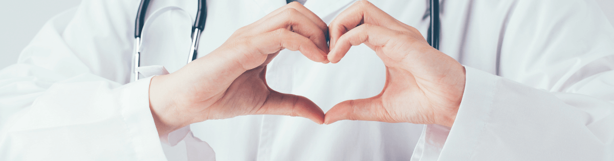 Doctor making a heart with their hands.