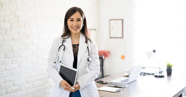 Woman in white coat smiles at camera in clinical setting