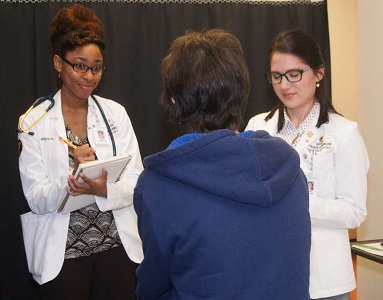 Medical students talking to a patient.