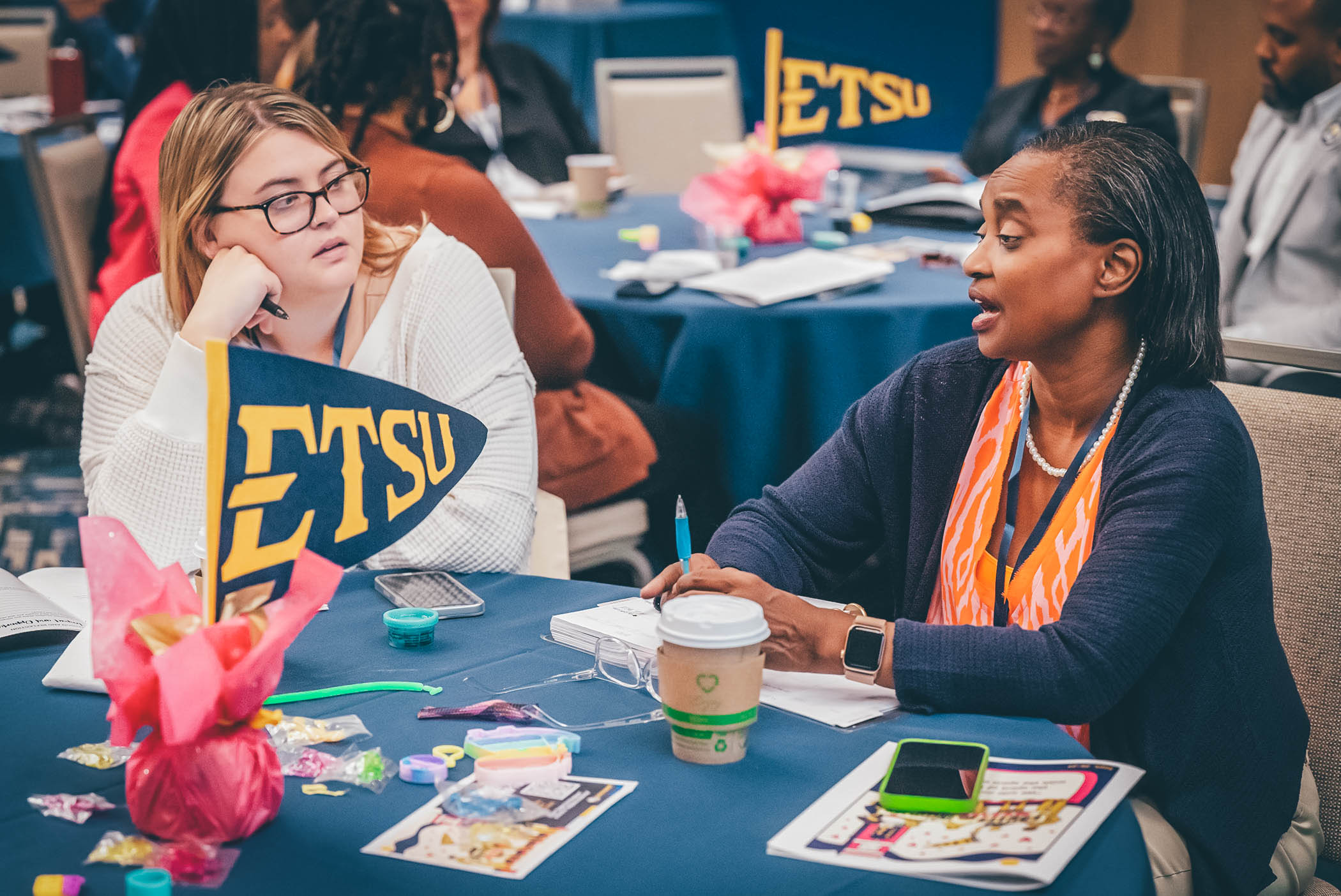 Attendees discuss with each other at a table.