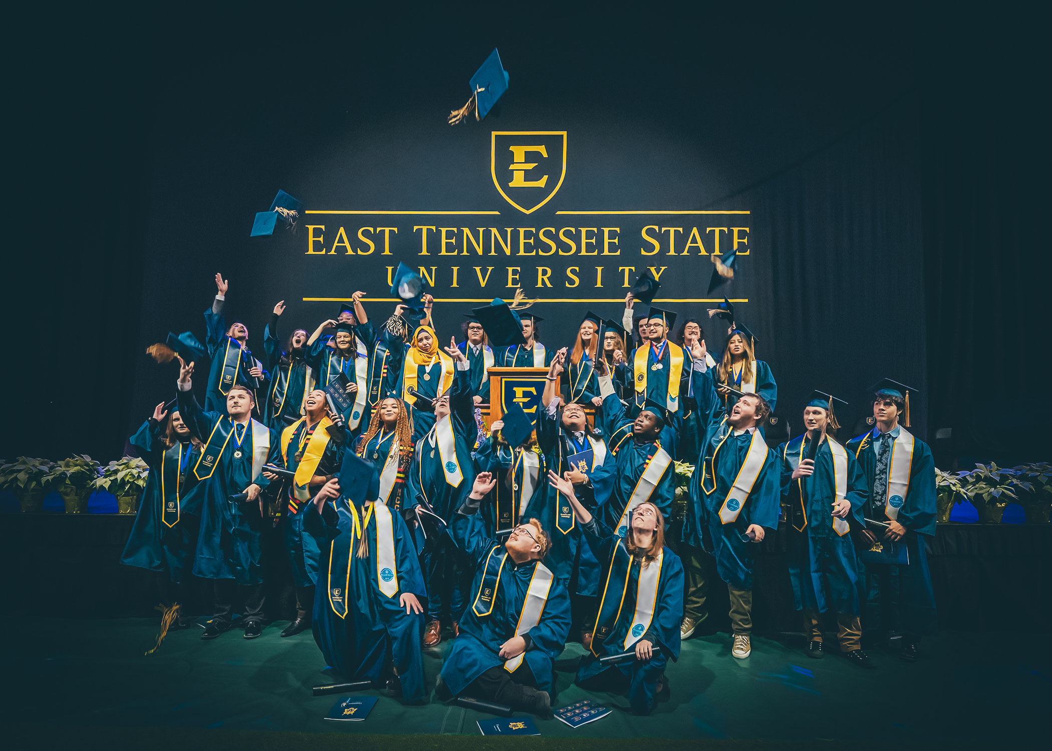 Graduates from the inaugural class of the BlueSky Tennessee Institute throwing their caps in the air at graduation