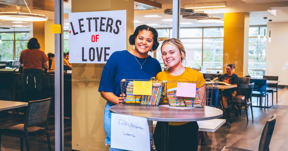 Two ETSU students posed together with the letters of love for first responders and hurricane survivors