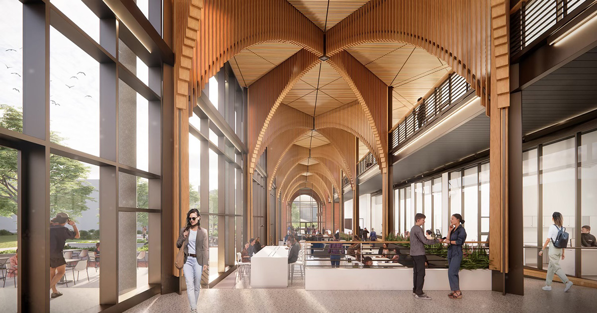Interior rendering of ETSU’s new academic building featuring a dramatic two-story commons with vaulted wood ceilings, large glass windows, and collaborative seating areas. Students talk in small groups, walk through the space, and sit at tables along a bright corridor overlooking an outdoor courtyard.