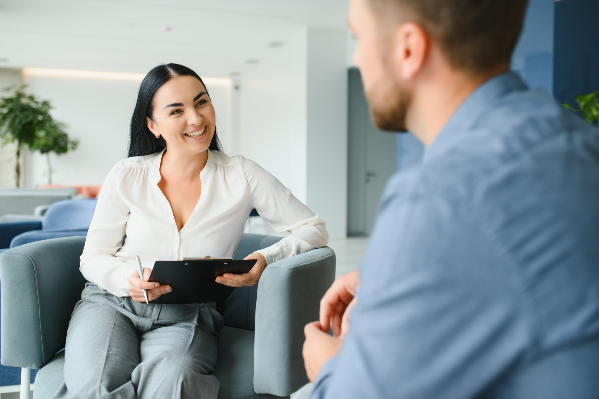 A man sits across from a woman counselor on a therapy session.