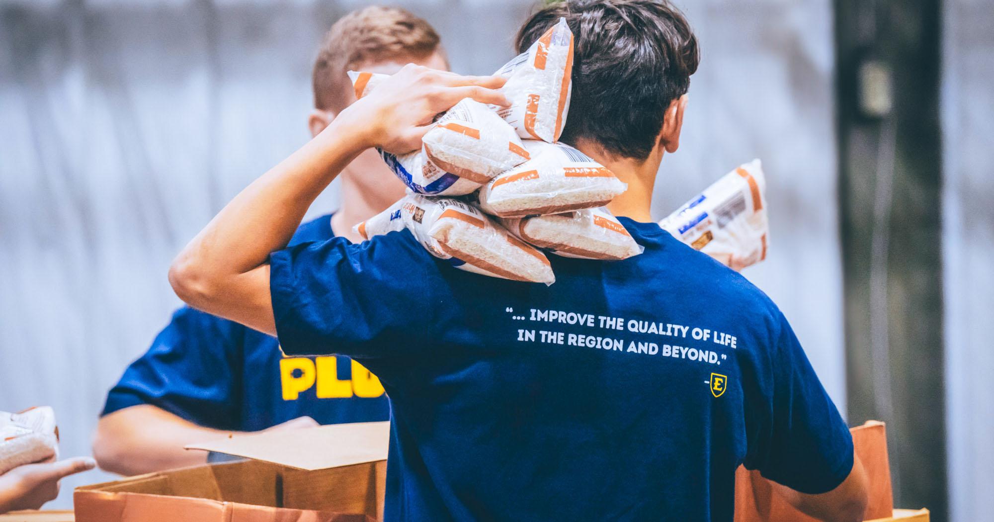 a student hold bags of food as part of relief efforts