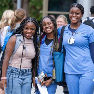 A group of students pose with smiles for the camera outside at the start of the semester.