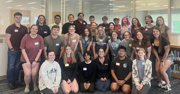 fall 2026 SI Leaders group picture - students in tiered rows standing in the back, squatting in the middle, and kneeling on the floor