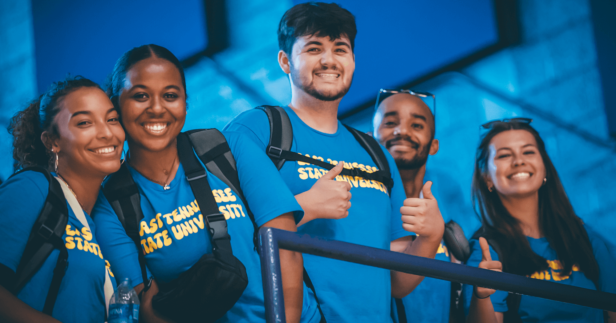 A group of students all wearing ETSU shirts gives the thumbs up for the camera.